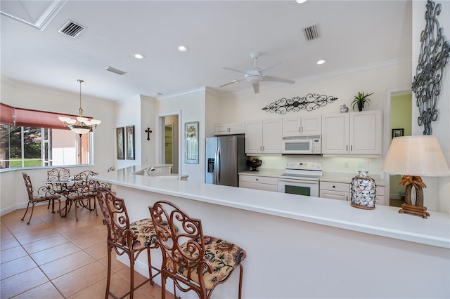 4308 Via Del Santi, Venice, FL 34293 - kitchen with white appliances, crown molding, light tile patterned floors, a peninsula, and pendant lighting
