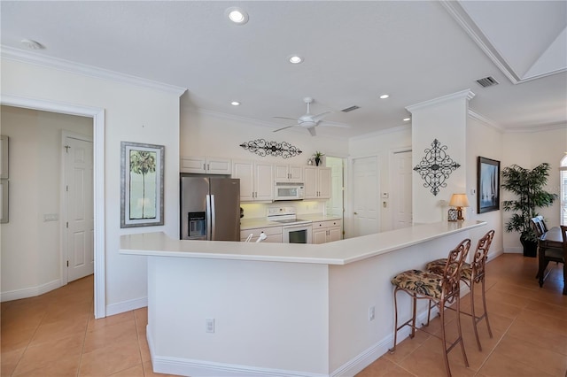 4308 Via Del Santi, Venice, FL 34293 - kitchen featuring white appliances, light tile patterned flooring, a ceiling fan, recessed lighting, and a breakfast bar