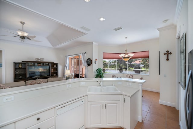 4308 Via Del Santi, Venice, FL 34293 - kitchen with white dishwasher, crown molding, light tile patterned floors, decorative light fixtures, and white cabinets