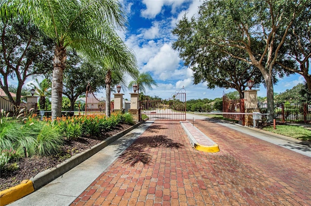 4308 Via Del Santi, Venice, FL 34293 - view of decorative street featuring a gate, a gated entry, curbs, and street lighting