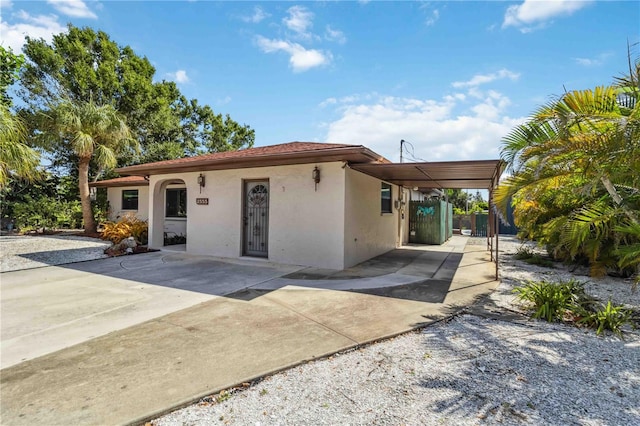 2555 Yucca Rd, Venice, FL 34293 - view of front of house with stucco siding, concrete driveway, and a carport