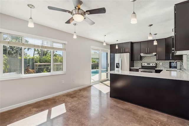 2555 Yucca Rd, Venice, FL 34293 - kitchen featuring stainless steel appliances, concrete floors, under cabinet range hood, light countertops, and a peninsula