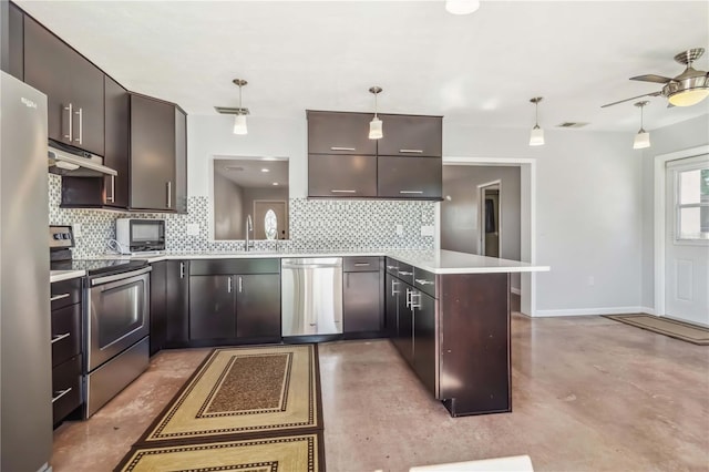 2555 Yucca Rd, Venice, FL 34293 - kitchen with appliances with stainless steel finishes, under cabinet range hood, a peninsula, and tasteful backsplash