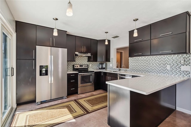 2555 Yucca Rd, Venice, FL 34293 - kitchen with stainless steel appliances, under cabinet range hood, a peninsula, decorative light fixtures, and light countertops