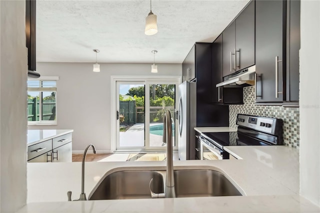 2555 Yucca Rd, Venice, FL 34293 - kitchen featuring stainless steel appliances, under cabinet range hood, tasteful backsplash, light countertops, and a textured ceiling