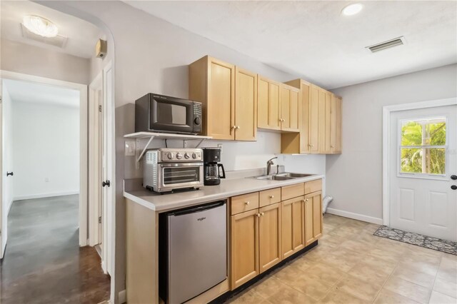 2555 Yucca Rd, Venice, FL 34293 - kitchen with fridge, light brown cabinets, light countertops, black microwave, and recessed lighting