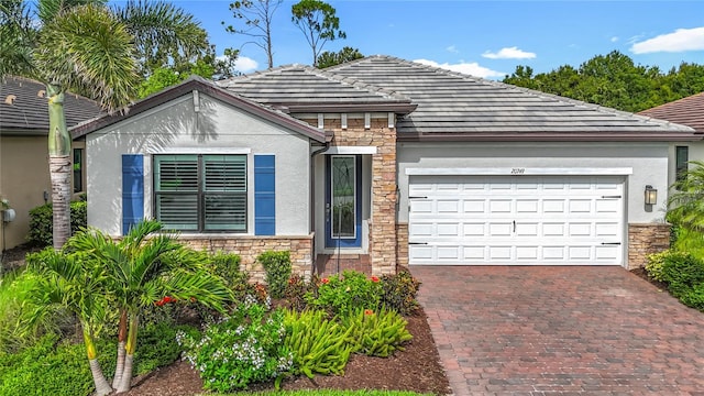 20749 Swallowtail Ct, Venice, FL 34293 - view of front of house featuring stone siding, stucco siding, an attached garage, and decorative driveway