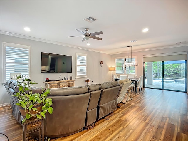 20749 Swallowtail Ct, Venice, FL 34293 - living room with ceiling fan, light wood-style flooring, ornamental molding, recessed lighting, and a chandelier