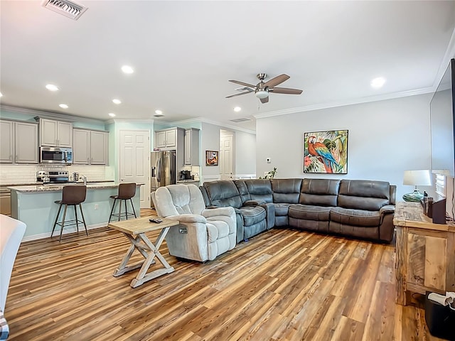 20749 Swallowtail Ct, Venice, FL 34293 - living room with crown molding, light wood-type flooring, recessed lighting, and a ceiling fan