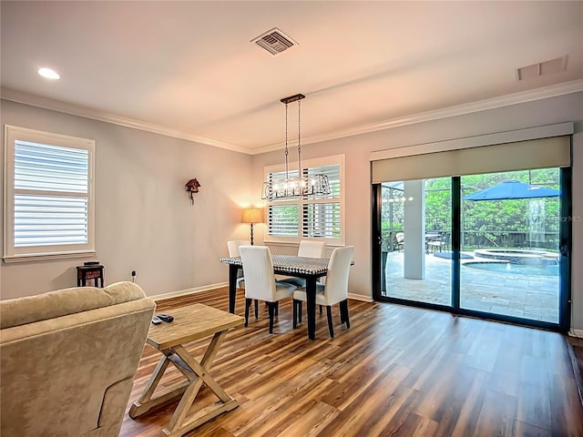 20749 Swallowtail Ct, Venice, FL 34293 - dining space with crown molding, wood finished floors, a chandelier, and recessed lighting