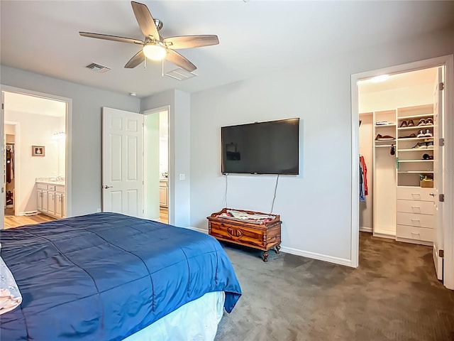 20749 Swallowtail Ct, Venice, FL 34293 - bedroom with a spacious closet, carpet, ceiling fan, ensuite bath, and a closet