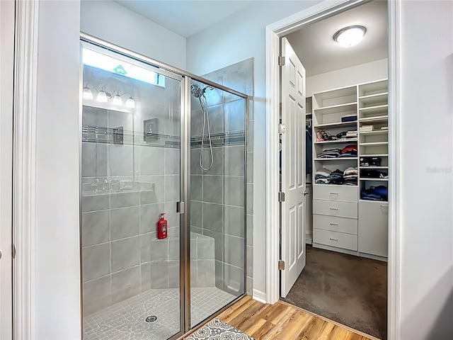 20749 Swallowtail Ct, Venice, FL 34293 - bathroom with a stall shower, a spacious closet, and wood finished floors
