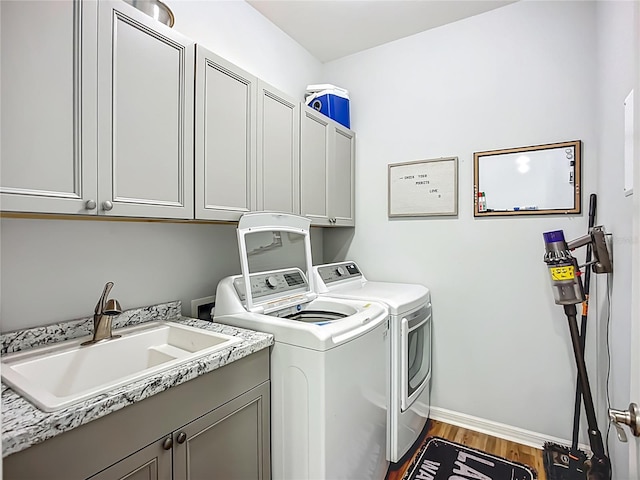 20749 Swallowtail Ct, Venice, FL 34293 - laundry room featuring cabinet space, washer and clothes dryer, and wood finished floors