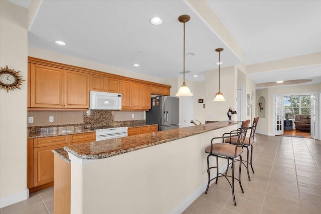 157 Tampa Ave E Unit 305, Venice, FL 34285 - kitchen featuring white microwave, stainless steel fridge with ice dispenser, stove, light tile patterned floors, and a breakfast bar area