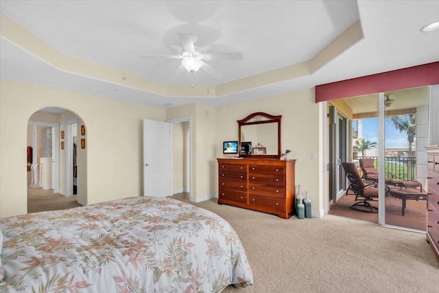 157 Tampa Ave E Unit 305, Venice, FL 34285 - bedroom featuring access to exterior, a tray ceiling, carpet floors, arched walkways, and ceiling fan