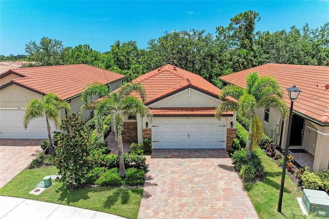257 Teramo Way, Nokomis, FL 34275 - mediterranean / spanish-style home featuring an attached garage, decorative driveway, a tiled roof, and stucco siding
