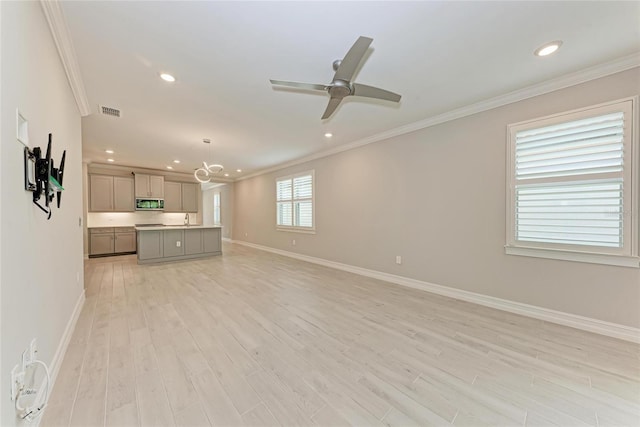 257 Teramo Way, Nokomis, FL 34275 - unfurnished living room featuring crown molding, light wood-style floors, recessed lighting, a chandelier, and a ceiling fan