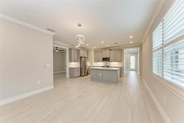 257 Teramo Way, Nokomis, FL 34275 - kitchen featuring gray cabinets, appliances with stainless steel finishes, crown molding, light countertops, and an island with sink