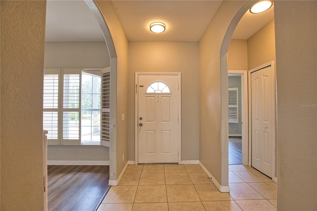 4150 Otoole St, North Port, FL 34291 - foyer featuring arched walkways, healthy amount of natural light, a textured wall, and light tile patterned floors