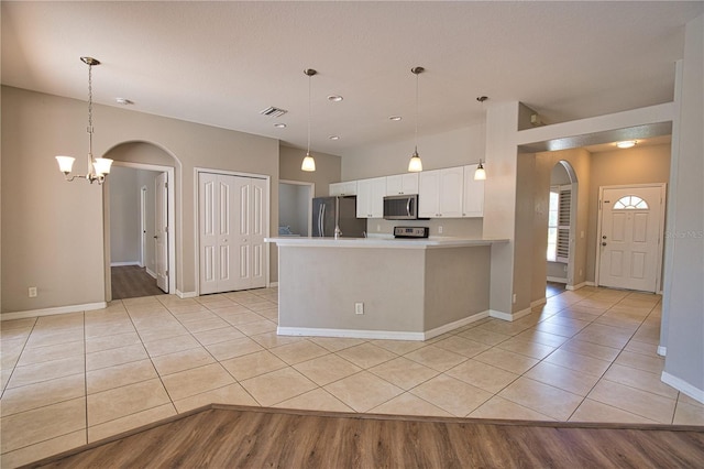 4150 Otoole St, North Port, FL 34291 - kitchen with stainless steel appliances, arched walkways, light countertops, white cabinetry, and light tile patterned floors