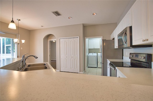 4150 Otoole St, North Port, FL 34291 - kitchen with appliances with stainless steel finishes, washing machine and dryer, arched walkways, a chandelier, and white cabinetry