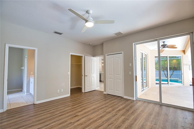 4150 Otoole St, North Port, FL 34291 - unfurnished bedroom with access to exterior, wood finished floors, ensuite bathroom, and ceiling fan