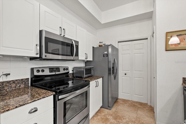 5134 Northridge Rd Unit 303, Sarasota, FL 34238 - kitchen featuring stainless steel appliances, white cabinetry, dark stone countertops, and decorative backsplash