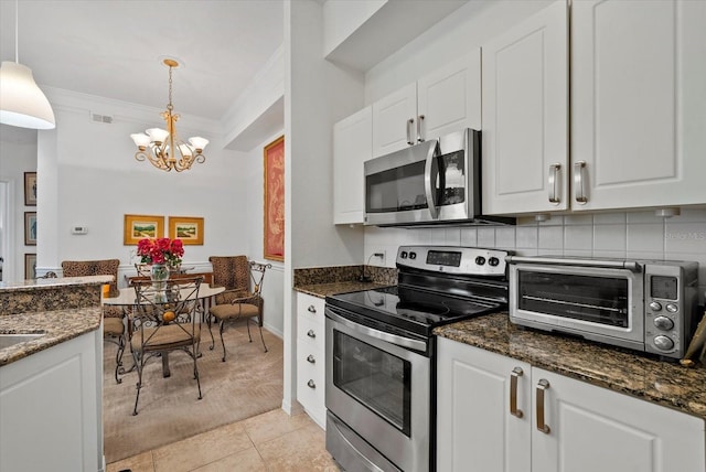 5134 Northridge Rd Unit 303, Sarasota, FL 34238 - kitchen featuring stainless steel appliances, light colored carpet, a chandelier, white cabinets, and ornamental molding