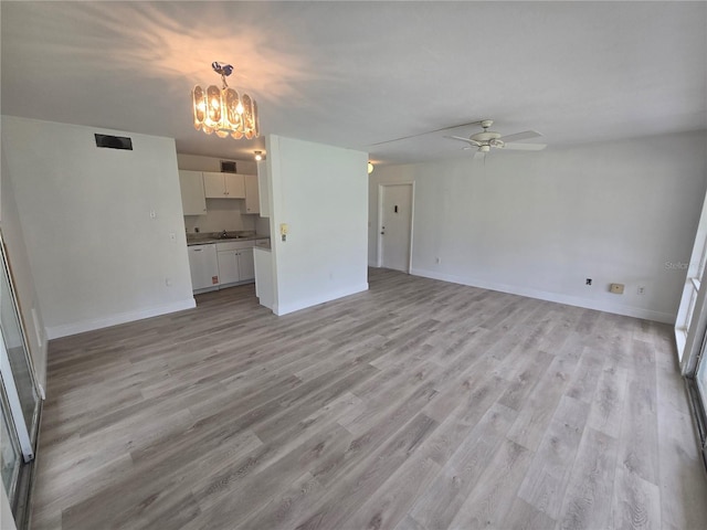 624 White Pine Tree Rd Unit 5, Venice, FL 34285 - unfurnished living room featuring a chandelier, light wood-type flooring, and ceiling fan