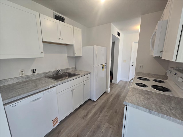 624 White Pine Tree Rd Unit 5, Venice, FL 34285 - kitchen with white appliances, wood finished floors, and white cabinets