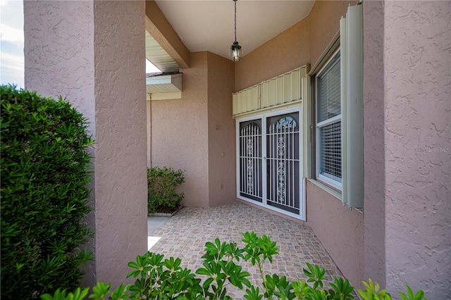519 Catalina Isles Cir, Venice, FL 34292 - view of exterior entry featuring stucco siding and a patio area