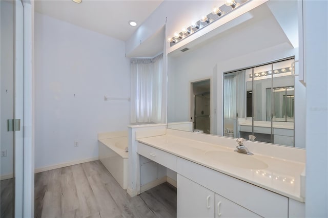 519 Catalina Isles Cir, Venice, FL 34292 - full bath featuring vanity, a garden tub, wood finished floors, and recessed lighting