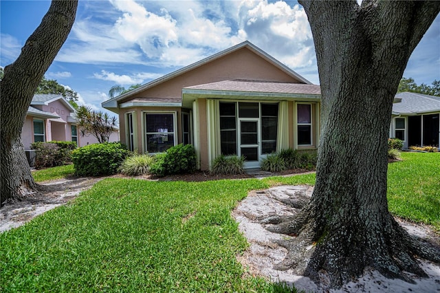 519 Catalina Isles Cir, Venice, FL 34292 - view of front of house with a front lawn, a sunroom, and stucco siding