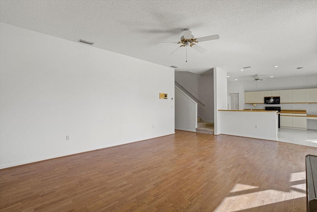 9528 Knightsbridge Cir, Sarasota, FL 34238 - unfurnished living room featuring a ceiling fan, wood finished floors, stairway, a textured ceiling, and recessed lighting