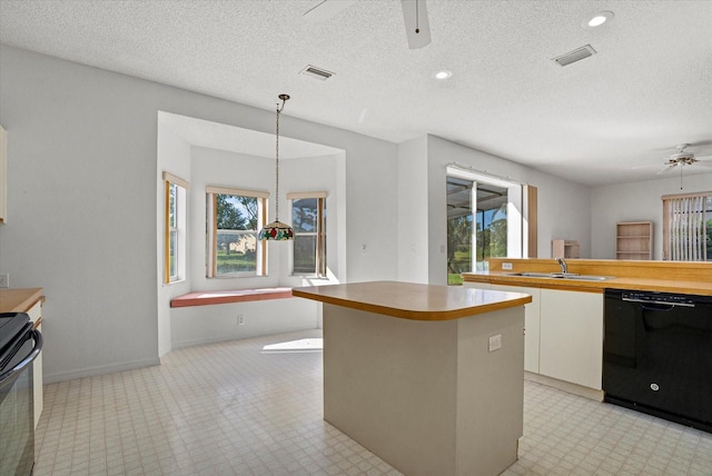 9528 Knightsbridge Cir, Sarasota, FL 34238 - kitchen featuring black dishwasher, a ceiling fan, range, white cabinetry, and a kitchen island