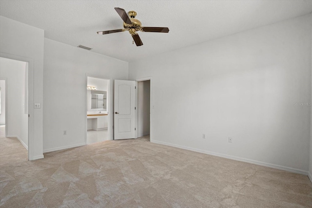 9528 Knightsbridge Cir, Sarasota, FL 34238 - unfurnished bedroom featuring carpet, connected bathroom, a ceiling fan, and a textured ceiling
