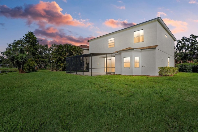 9528 Knightsbridge Cir, Sarasota, FL 34238 - rear view of property featuring a yard, stucco siding, and glass enclosure