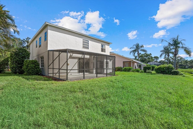 9528 Knightsbridge Cir, Sarasota, FL 34238 - back of house featuring stucco siding, a yard, and glass enclosure