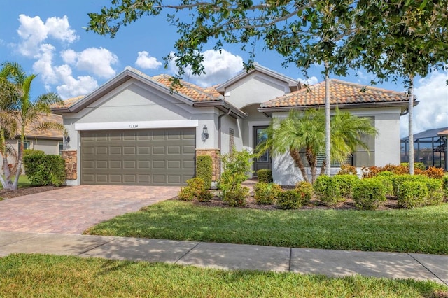 13334 Pacchio St, Venice, FL 34293 - mediterranean / spanish home featuring an attached garage, decorative driveway, a front yard, stucco siding, and a tile roof