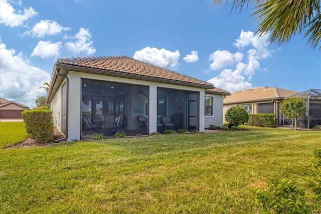 13334 Pacchio St, Venice, FL 34293 - back of house featuring a tile roof, a lawn, stucco siding, and a sunroom