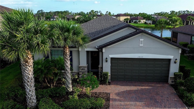 2487 Marton Oak Blvd, North Port, FL 34289 - ranch-style house with stucco siding, decorative driveway, a garage, and stone siding