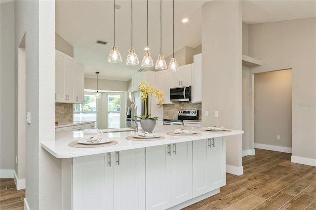 26115 Rampart Blvd, Punta Gorda, FL 33983 - kitchen featuring stainless steel appliances, decorative backsplash, light countertops, light wood-style floors, and white cabinetry