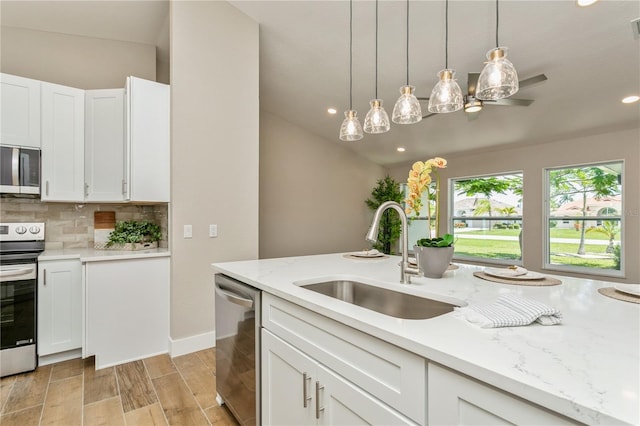 26115 Rampart Blvd, Punta Gorda, FL 33983 - kitchen featuring stainless steel appliances, tasteful backsplash, white cabinetry, pendant lighting, and recessed lighting