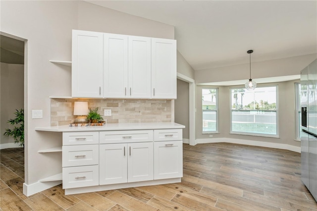 26115 Rampart Blvd, Punta Gorda, FL 33983 - kitchen with open shelves, vaulted ceiling, white cabinets, light countertops, and tasteful backsplash