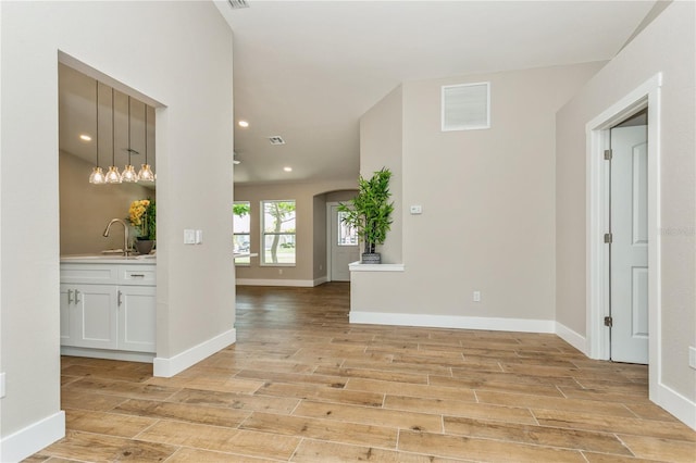 26115 Rampart Blvd, Punta Gorda, FL 33983 - hall with light wood-style floors, recessed lighting, and arched walkways