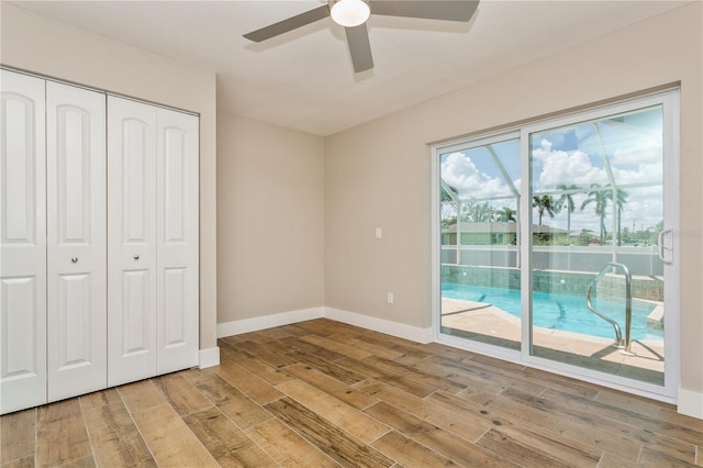 26115 Rampart Blvd, Punta Gorda, FL 33983 - unfurnished bedroom with access to outside, wood finished floors, a closet, and ceiling fan