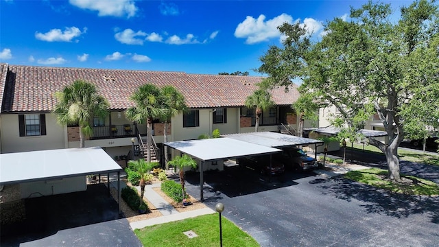 330 Mission Trl N Unit F, Venice, FL 34285 - view of front facade with a tiled roof, stucco siding, and stairs
