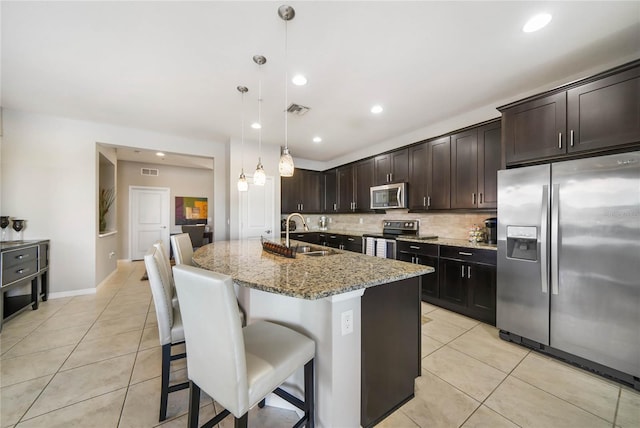 23527 Awabuki Unit 202, Venice, FL 34293 - kitchen featuring appliances with stainless steel finishes, light tile patterned floors, decorative backsplash, light stone counters, and recessed lighting