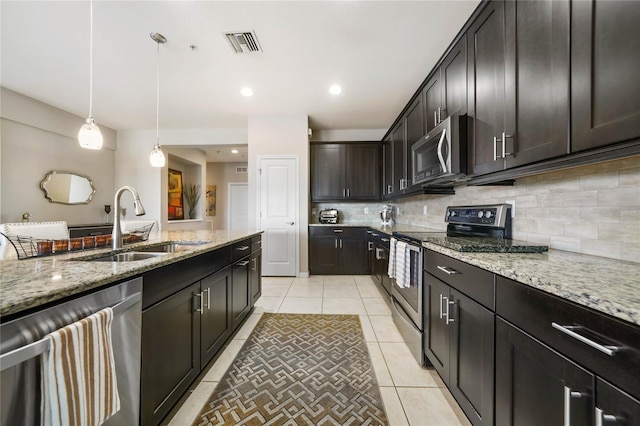 23527 Awabuki Unit 202, Venice, FL 34293 - kitchen with stainless steel appliances, tasteful backsplash, light tile patterned floors, light stone counters, and hanging light fixtures