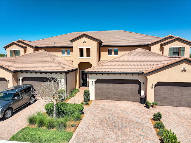 23527 Awabuki Unit 202, Venice, FL 34293 - view of front of home with stucco siding, a garage, decorative driveway, and a tiled roof